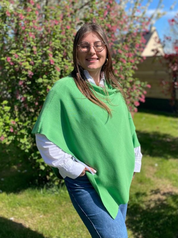 Poncho en 100% mérinos extrafin couleur vert pistache porté par une femme dans un jardin ensoleillé