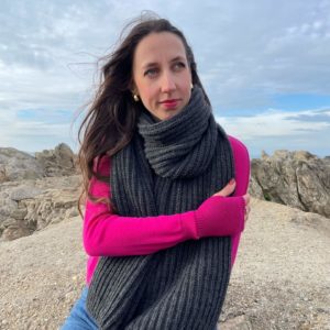 Echarpe Anglaise de couleur anthracite portée par une femme assise sur un rocher
